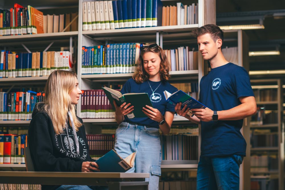 Troje studentów (dwie studentki i student) w bibliotece