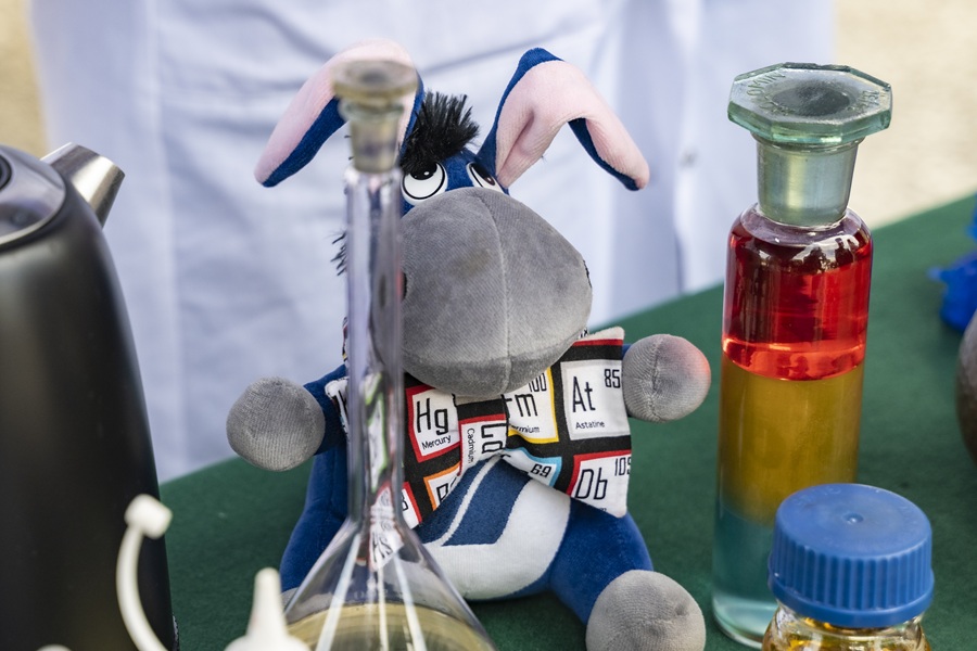 Uniwersytecka maskotka (Usiołek) na stole wśród probówek Chemicznych